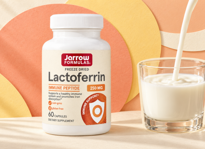 Лактоферрин Jarrow Formulas 250 мг, 60 капсул — упаковка добавки и стакан молока на персиковом фоне